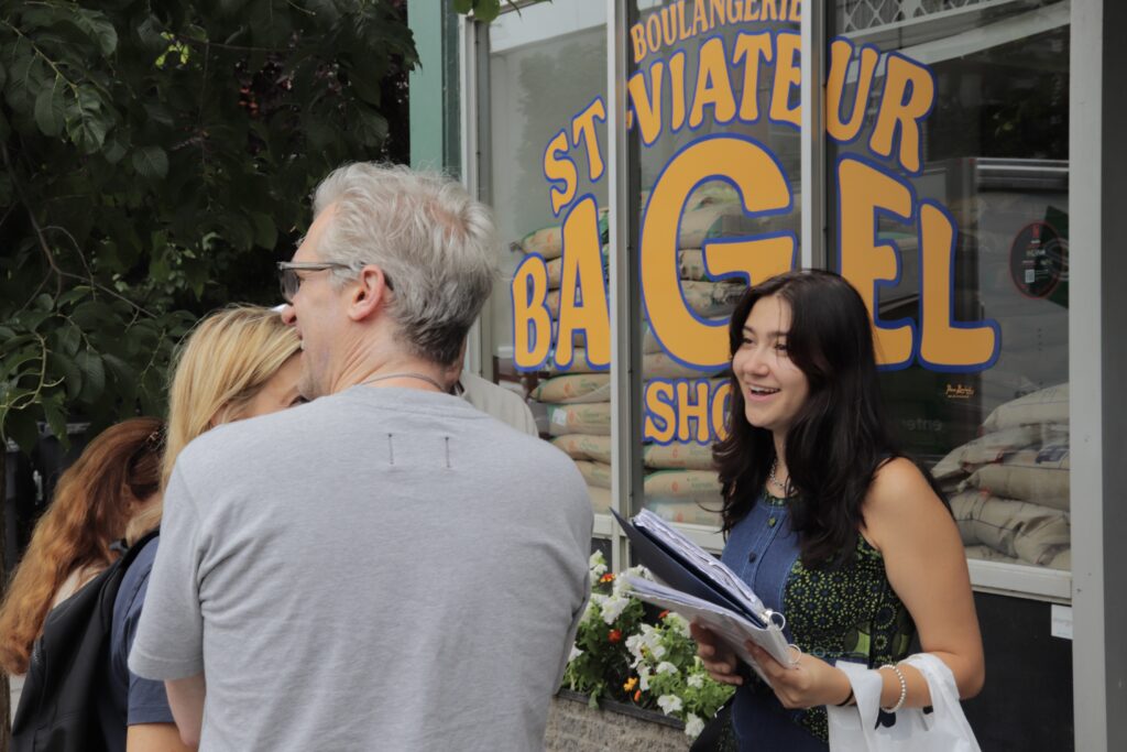 Museum Educator leading a beyond the bagel food tour, outside of St-Viator Bagel