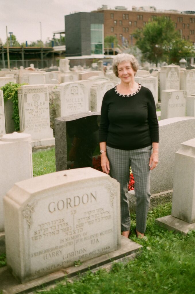 Woman standing next to a tombstone