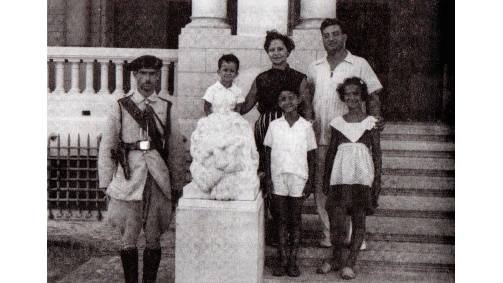 An armed guard and the Schinasi family in front of the Montazah Palace in Alexandria, summer 1956.