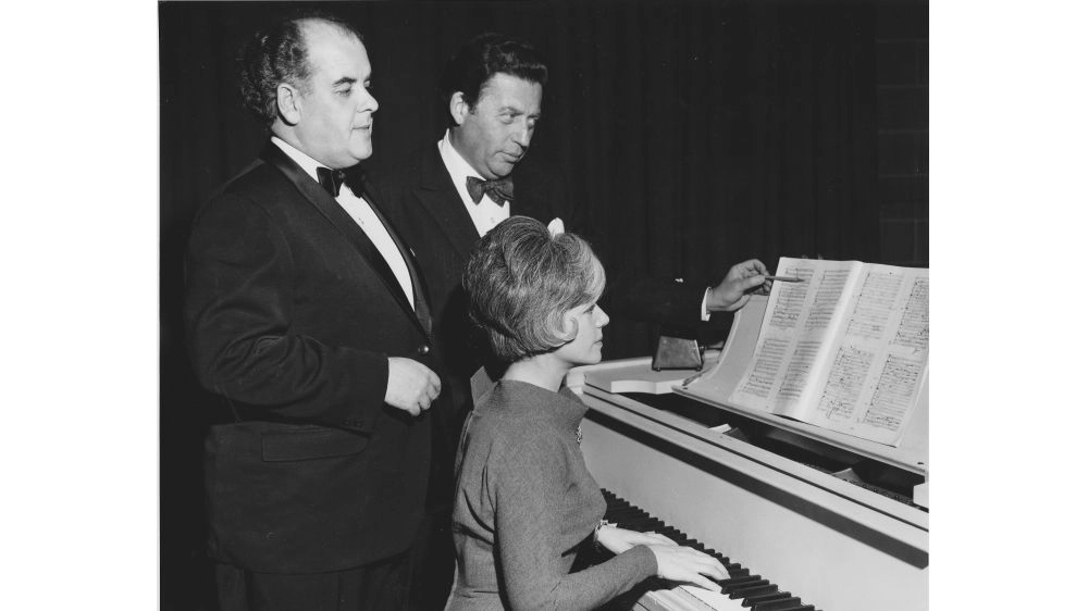 Rebecca Stotland, Alexander Brott (pointing at piano book) and unknown man. Performance during the TV show u201cMusic Roomu201d, produced for CFCF TV Montreal. Year unknown.